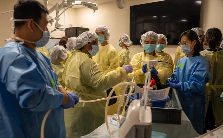 Gowned participants with scopes in the surgical skills wet lab
